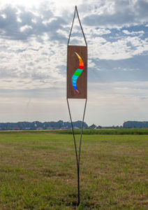 Gartenstele mit einem wellenförmigen Farbenspiel aus Glas, in einem Holzrahmen eingearbeitet in zwei Flacheisen.
