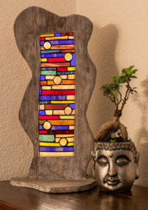 Bunte Glaslampe aus Rechtecken und großen Glasnuggets. Rahmen in Wellenform und Vintage Look. Lampe ist direkt mit dem Lampenfuß verbunden.